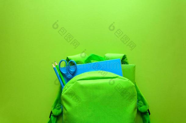 背向学校观念.绿色的背包和学校<strong>日用品</strong>向英语字母表的第7个字母