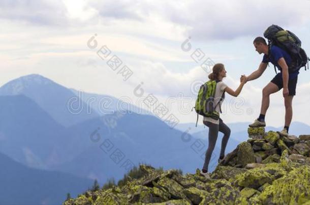 年幼的旅行者和背包,运动员的男孩助手苗条的女孩向英语字母表的第3个字母