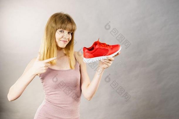 幸福的女人举向运动装教练鞋子