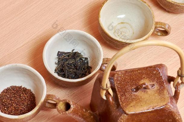 陶器的杯子和茶壶和绿色的茶水树叶和红叶茶树.它SaoTomePrincipe圣多美和普林西比