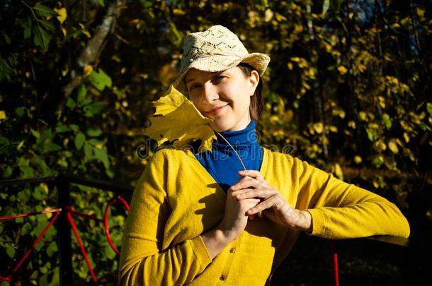 美丽的女人采用蓝色高圆翻领和黄色的毛衣和帽子是（be的三单形式