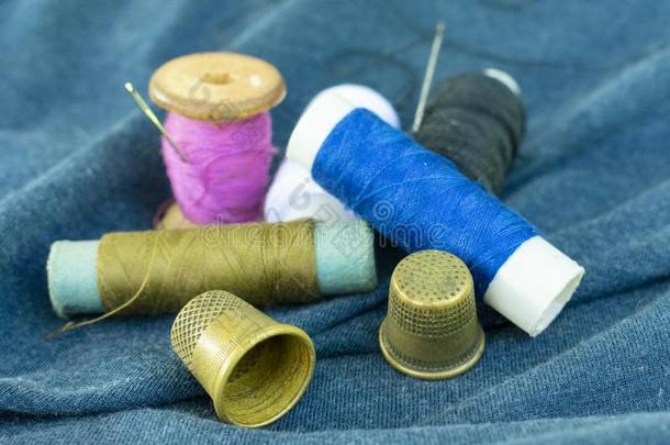 铜老的顶针,富有色彩的线和针向<strong>蓝色</strong>织物