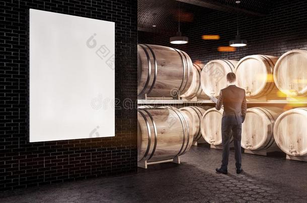 黑的砖葡萄酒地下室,小桶和海报,男人