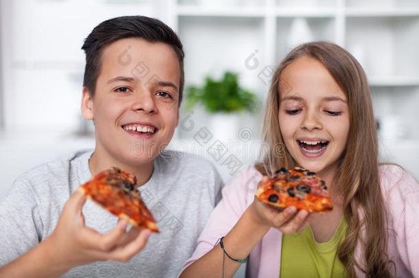 幸福的少年男女吃意大利薄饼
