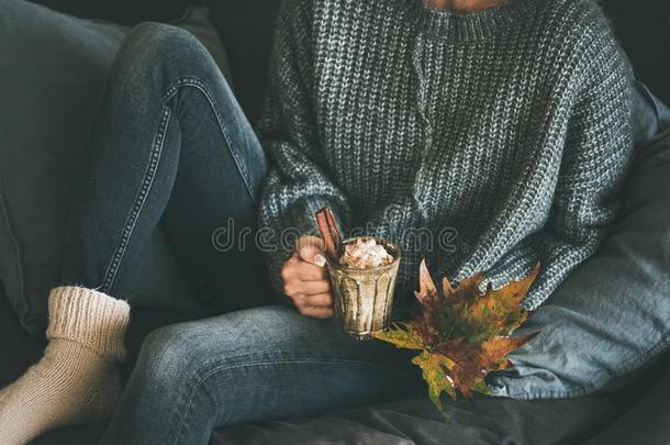女人采用羊毛制的毛衣hold采用g马克杯和热的巧克力