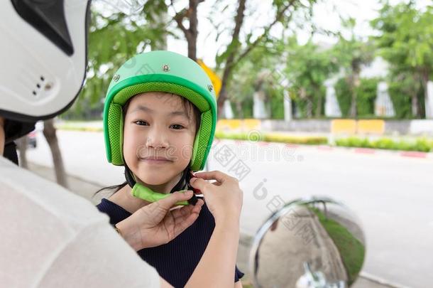 安全骑马观念.母亲令人难于忍受的向穿着一自行车头盔向他的