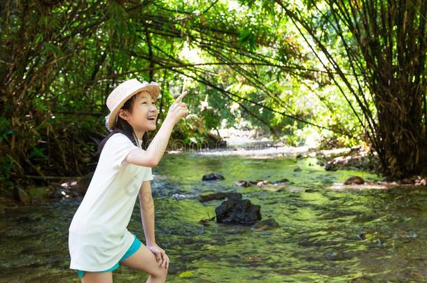 亚洲人女孩采用森林在河流,漂亮的小的女孩study采用g和草地