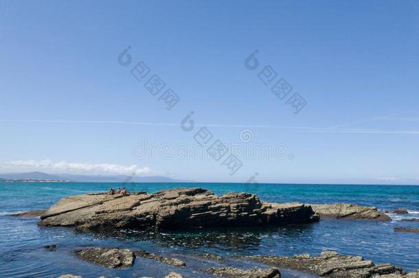 极好的风景关于和煦的：照到阳光的海滩紧接在后的向大大地岩石和蓝色