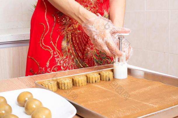 亚洲人中国人女人制造月亮蛋糕采用指已提到的人厨房
