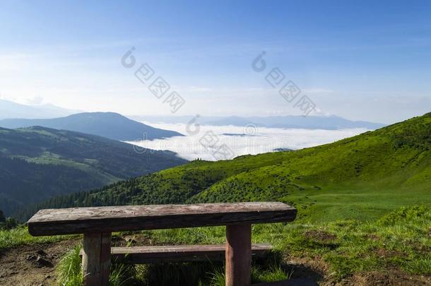 木制的长凳反对山山谷和清楚的蓝色天