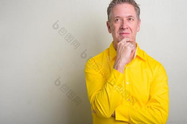 肖像关于成熟的商人使人疲乏的黄色的衬衫