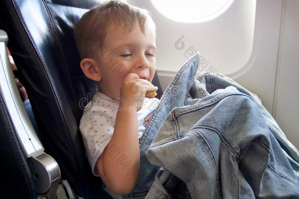 肖像关于有趣的蹒跚行走的人男孩吃在的时候飞行采用飞机