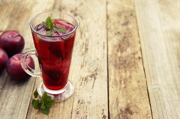 红色的药草的和成果茶水采用玻璃杯子和茶水和李子.乡村的