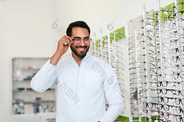 眼镜商男人在近处玻璃柜台和眼镜在眼镜商店