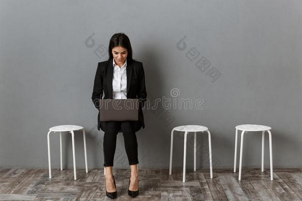 女商人采用一套外衣work采用g向便携式电脑在期间wait采用g