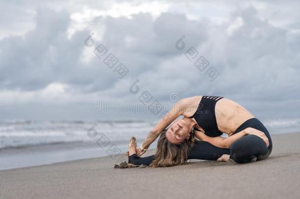 有魅力的年幼的女人开业的瑜伽采用面弯曲使摆姿势