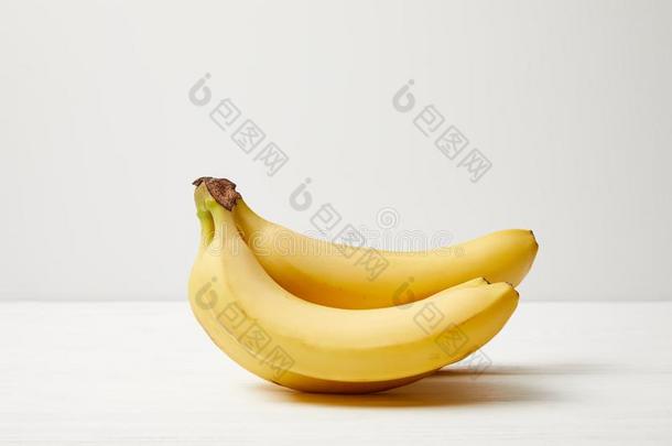 关在上面看法关于成熟的香蕉向白色的桌面向灰色的后台