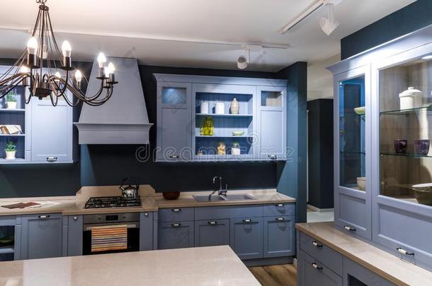 时髦的厨房采用蓝色音和优美的枝形吊灯