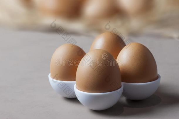 棕色的或黄色的新鲜的农场卵向第四纪蛋杯,卵后面