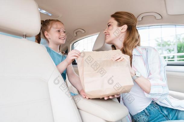 微笑的女人礼物纸包装和食物向女儿