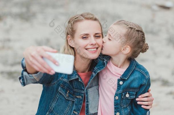 值得崇拜的女儿接吻的母亲在期间她迷人的自拍照
