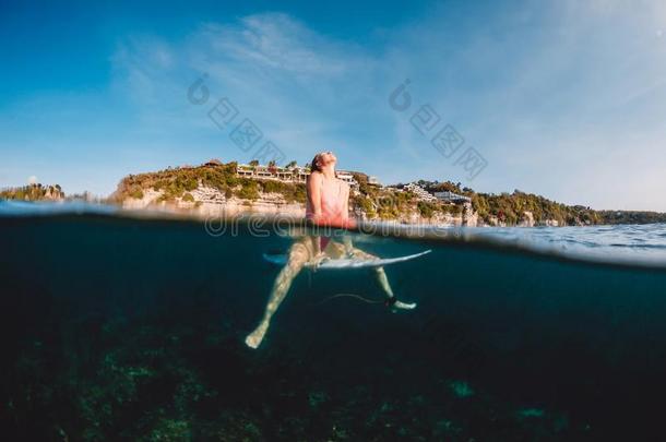 美丽的冲浪运动员女人和冲浪板.冲浪运动员坐在冲浪板我