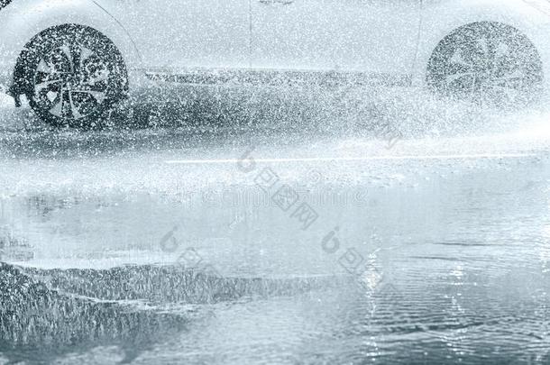 雨水喷雾从汽车轮子活动的向被水淹的路
