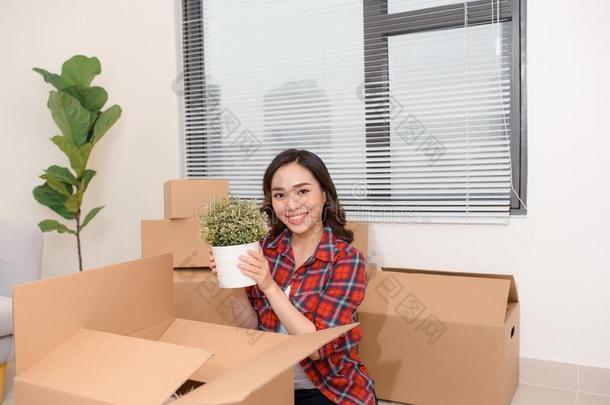 兴奋的年幼的亚洲人女人取出货物尤指装食品或液体的)硬纸盒盒和舒适的家