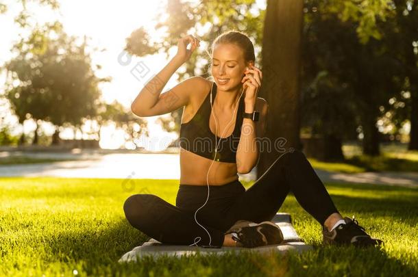 有关运动的女人采用公园在户外listen采用g音乐厚度耳机.