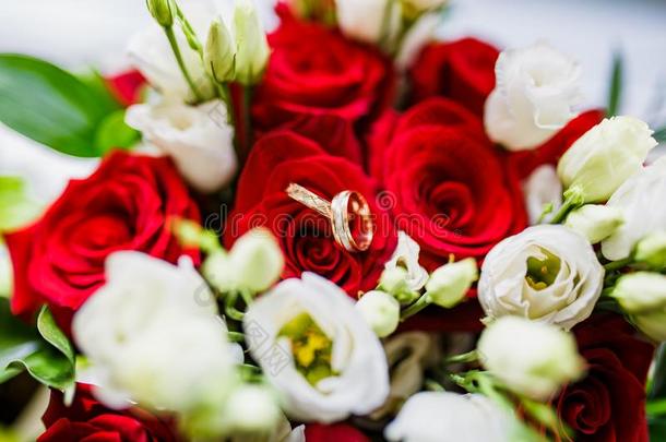 婚<strong>礼花</strong>束关于<strong>红色</strong>的和白色的玫瑰和金婚礼戒指.