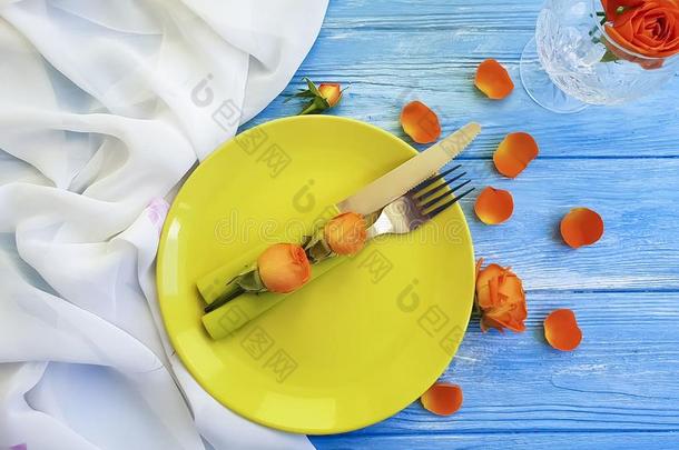 盘子,餐叉刀,玫瑰花向蓝色木制的背景