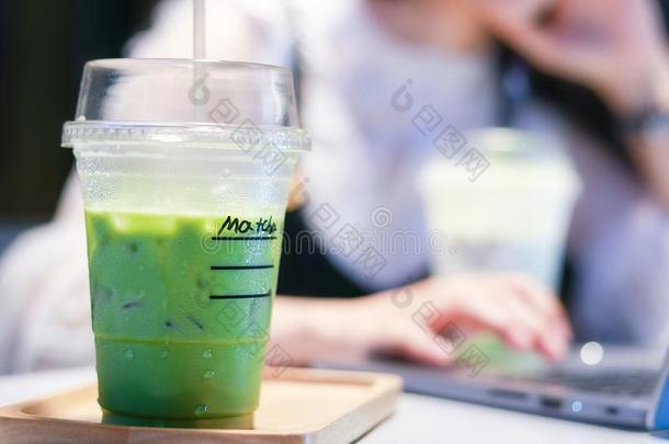 <strong>冰</strong>冷的日本<strong>抹茶</strong>绿色的茶水拿铁咖啡向表和女人工作的采用商店