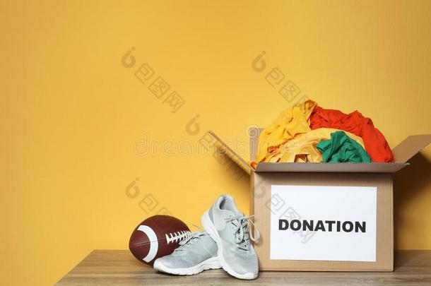 捐赠盒和衣服,鞋子和橄榄球运动球向表反对