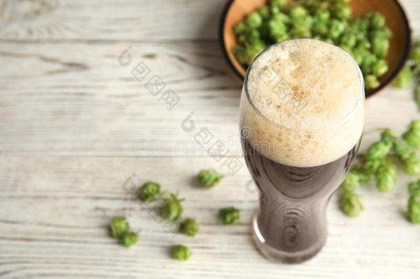 作品和美味的啤酒和新鲜的绿色的跳上向木制的表