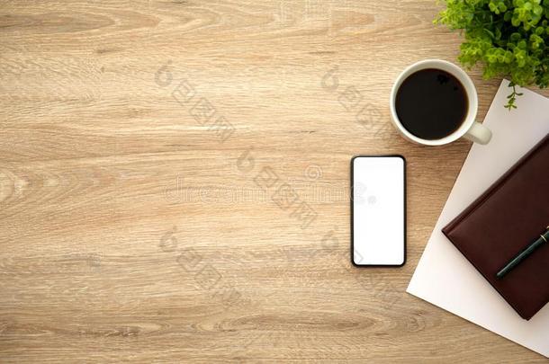 电话和隔离的屏幕向木制的表在近处笔记簿咖啡豆