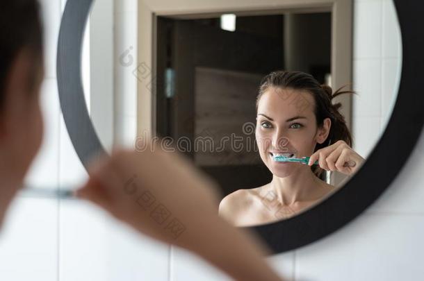 年幼的黑头发的妇女女人疾驰的她牙采用前面关于浴室米尔