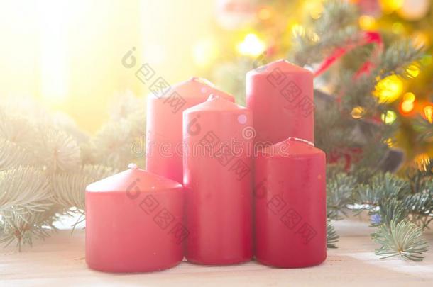红色的圣诞节蜡烛向一发光的b一ckground和圣诞节树