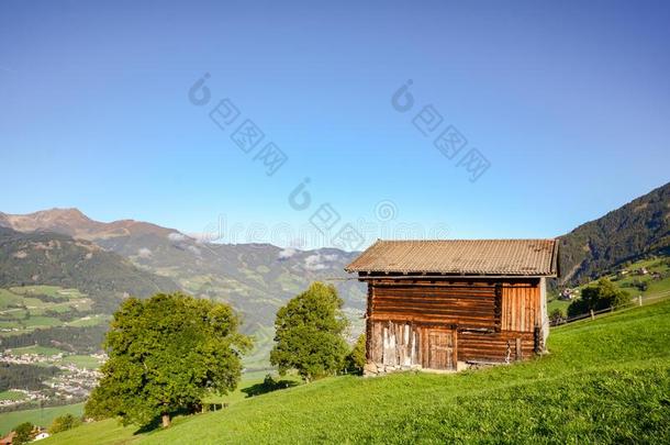 阿尔卑斯山的牧草地徒步旅行向一老的木制的谷仓和山草地我