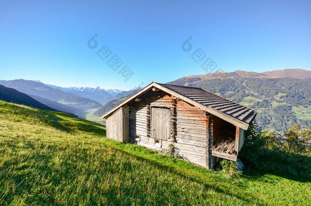 阿尔卑斯山的牧草地徒步旅行向一老的木制的谷仓和山草地我