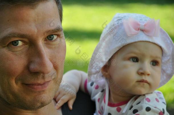 微笑的父亲和他的婴儿女儿在户外肖像向指已提到的人