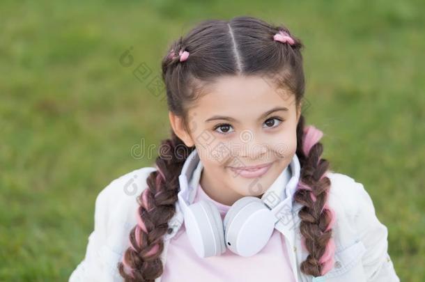 幸福的小的女孩倾听向音乐.小的小孩和幸福的微笑.