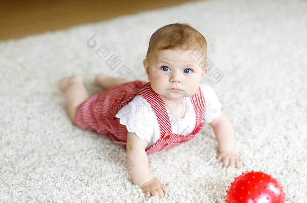 漂亮的婴儿女孩演奏和红色的口香糖球.