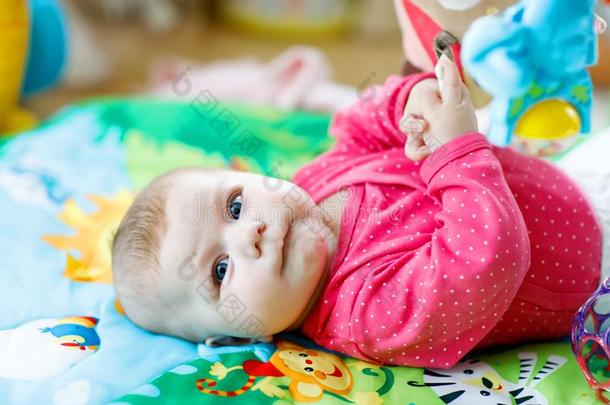 漂亮的值得崇拜的新生的婴儿演奏向富有色彩的<strong>玩具健身</strong>房