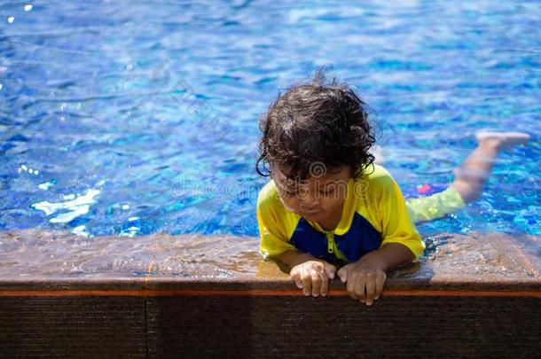 亚洲人小孩男孩学习游泳采用一游泳水池