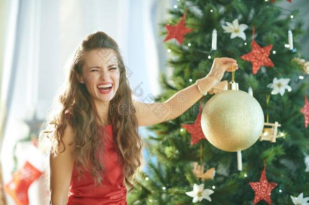 女人在近处<strong>圣诞</strong>节树展映大的金<strong>圣诞</strong>节球