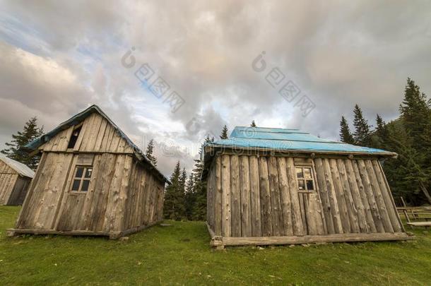 老的木制的牧羊人小屋向山绿色的山谷向蓝色云