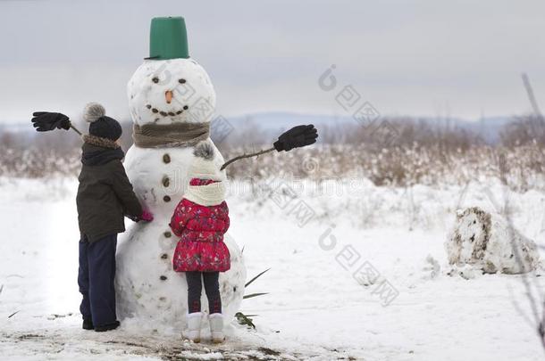 两个年幼的孩子们,男孩和女孩,完成做微笑的雪人我