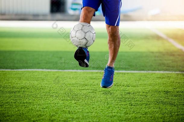 足球演员跳和拍摄球向目标向人造的草皮.
