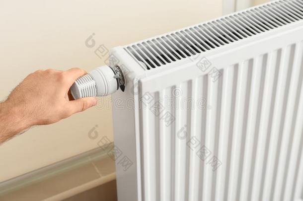 男人调节暖气装置暖气片恒温器
