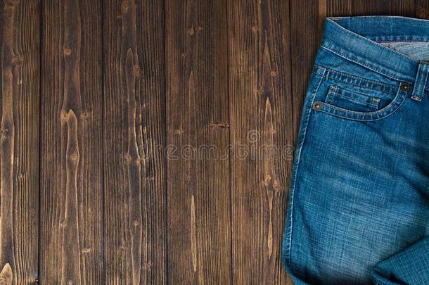 磨损的牛仔裤或蓝色牛仔裤斜纹粗棉布收集向粗糙的黑暗的木制的